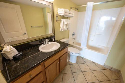 a bathroom with a sink and a toilet and a mirror at Oceanfront Convenience on Lower Floor, Heated Pool in Myrtle Beach
