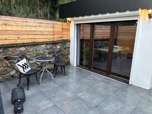 un patio con mesa, sillas y pared de piedra. en Suite Marie en Verviers