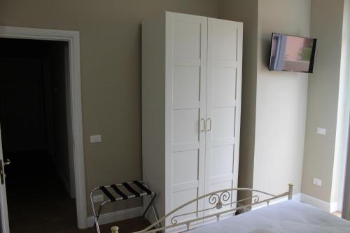 a bedroom with a white cabinet next to a bed at Casa Aydée in Bergamo