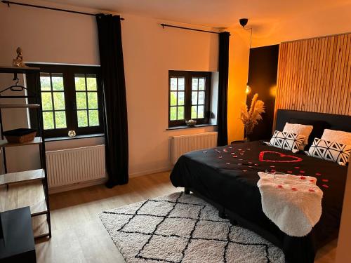 a bedroom with a black bed and a rug at Suite Marie in Verviers