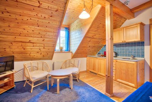 a kitchen with wooden walls and a table and chairs at Apartmán-Hotel Jítravský Dvorec in Rynoltice