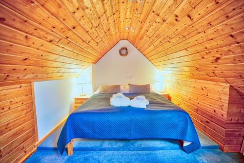 a bedroom with a large bed in a wooden ceiling at Apartmán-Hotel Jítravský Dvorec in Rynoltice