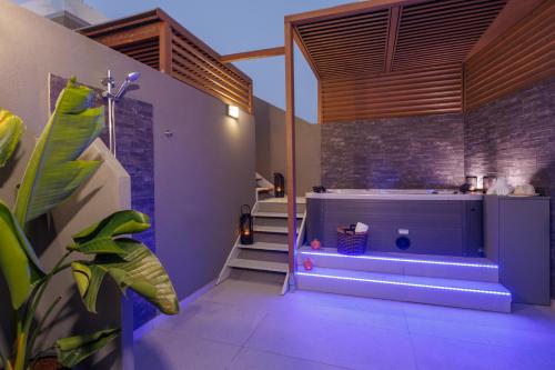 een badkamer met een bad en een trap in een kamer bij Hersonissos Beach Front Suites in Chersonissos