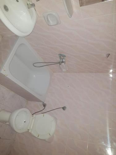 uma casa de banho com um WC branco e um lavatório. em فندق الامرات ٣٣ النيل em ‘Izbat al Jirabī