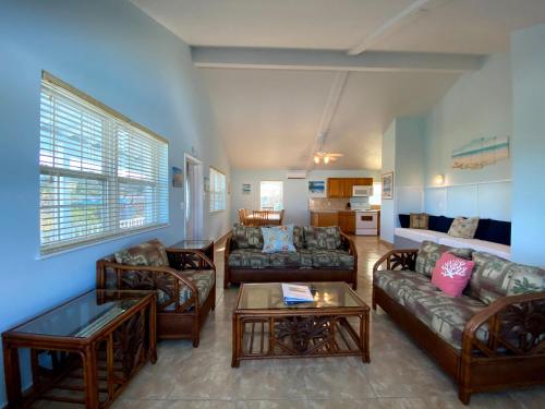 a living room with couches and a table at Hideaways Exuma in Georgetown