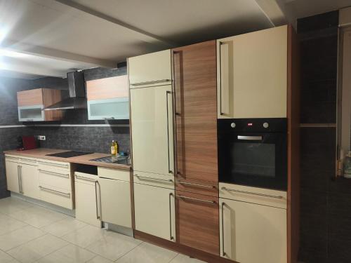 a kitchen with white appliances and wooden cabinets at Chambre climatisée cosy Auberge du Manala Hôtel 24-24 in Saint-Louis
