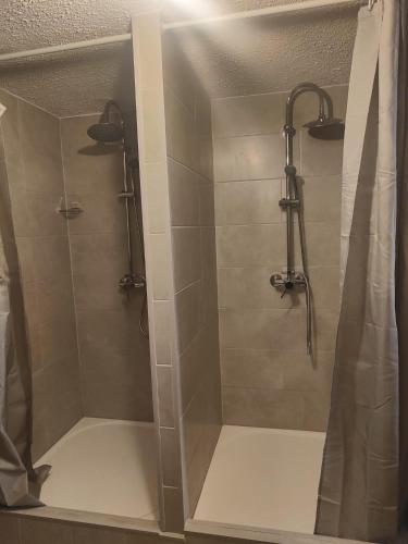 une douche avec une porte vitrée dans une salle de bain dans l'établissement Chambre climatisée cosy Auberge du Manala Hôtel 24-24, à Saint-Louis