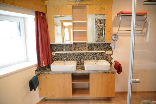 ein Badezimmer mit 2 Waschbecken und einem Spiegel in der Unterkunft Appartements Alpenblick in Kirchberg in Tirol