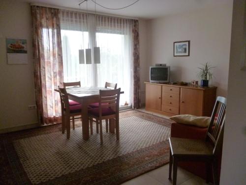 a dining room with a table and chairs and a television at Haus am Stellensee in Sternenfels