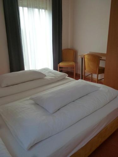 two white beds in a bedroom with a window at Haus am Stellensee in Sternenfels