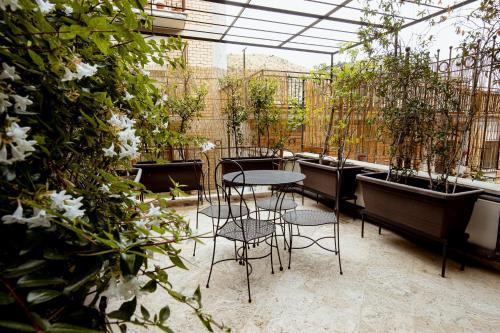 un patio con mesa, sillas y plantas en Al Catillo en Tivoli