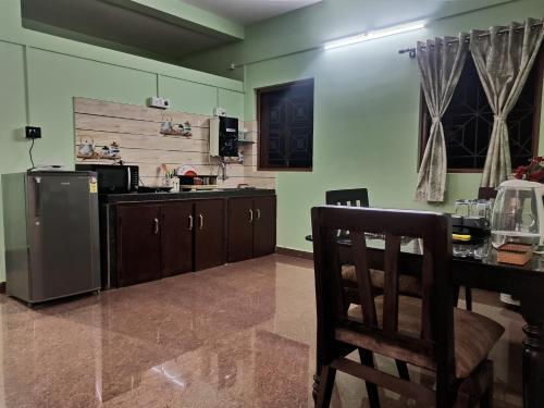 a kitchen with a table and a refrigerator at Benirosa Homestay Apartments 2 in Velcao