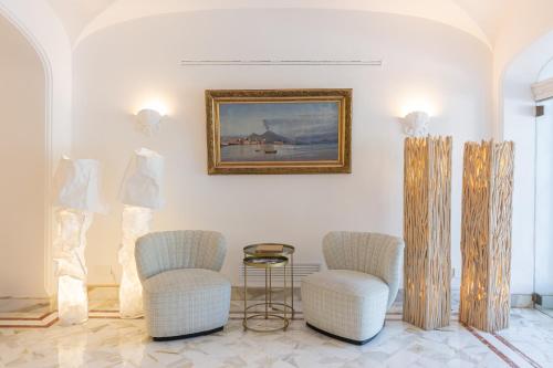 una habitación con 2 sillas y un cuadro en la pared en Hotel Mamela en Capri