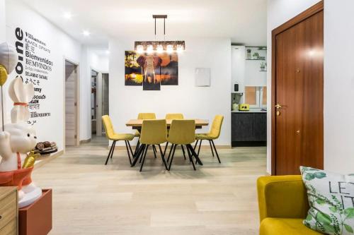 a dining room with a table and yellow chairs at LUJO: Parking, Proyector, Maquinita y Patinetes in Oviedo