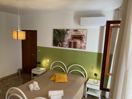 1 dormitorio con 1 cama con pared verde en All'Arena en Verona