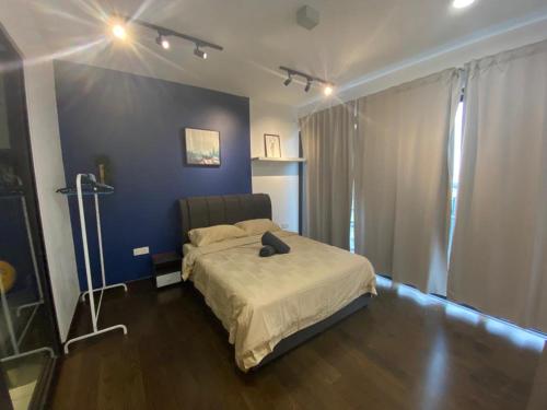 1 dormitorio con cama y pared azul en GS home en Nusajaya