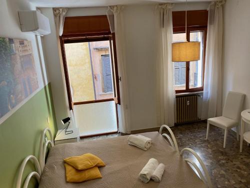 Un dormitorio con una cama con toallas amarillas. en All'Arena, en Verona