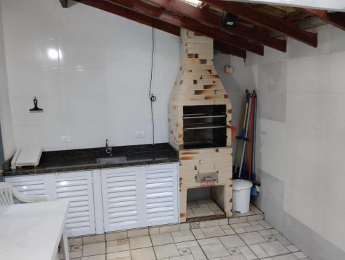 a kitchen with a brick oven in the corner at Recanto Vista Mar in Bertioga