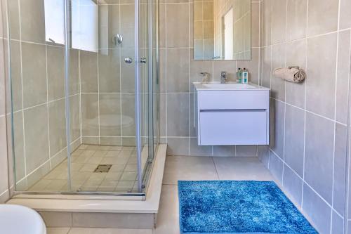 a bathroom with a shower and a blue rug at 535 Ballito Hills 2 Bedroom unit in Ballito