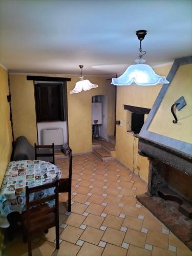ein Wohnzimmer mit einem Tisch und einem Kamin in der Unterkunft Casa Santa Maria in Frosolone