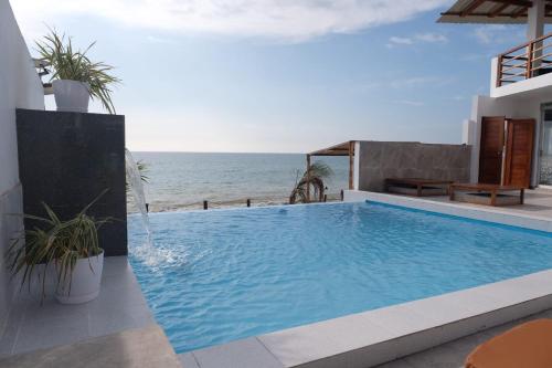una piscina con el océano en el fondo en Las Fragatas Casa Hotel, en Canoas de Punta Sal