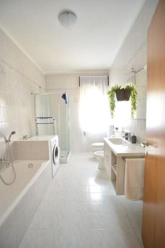 a white bathroom with a tub sink and a washing machine at Casa Laita in Sarego