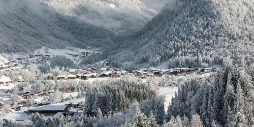 a village covered in snow with mountains in the background at Chalet Adonis - Montriond, Morzine, Avoriaz in Montriond