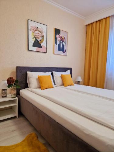 a large bed with orange and white pillows in a room at ORI Passion Apart. Malul Mureșului in Arad
