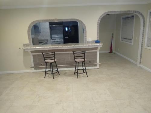 a kitchen with two bar stools and a counter at Sky Fresh Home Stay in Apple Valley