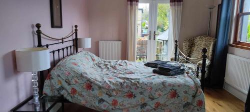 a bedroom with a bed with a flowered comforter at Beautiful self contained apartment with garden in Glasgow