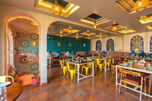 een restaurant met houten tafels en gele stoelen bij Blue Door in Būndi