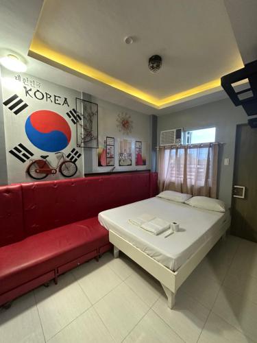 a bedroom with a bed and a red couch at Twilight Tower in Ormoc