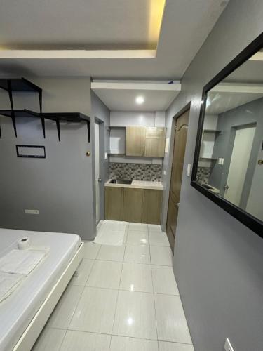 a room with a white tile floor and a kitchen at Twilight Tower in Ormoc