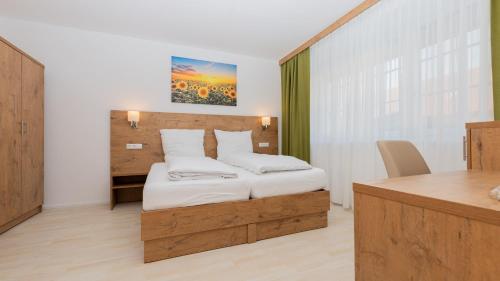 ein Schlafzimmer mit einem Bett und einem Schreibtisch in einem Zimmer in der Unterkunft Schönfelderhof 