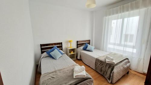 a bedroom with two beds and a window at Apartamento ZONA in Albacete