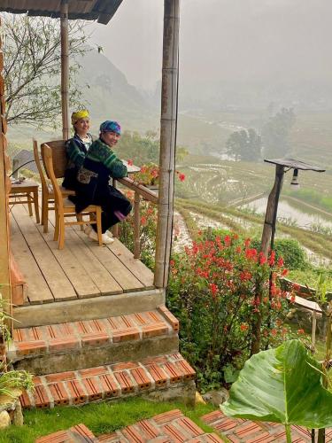 two people sitting on the porch of a house at SaPa Farmer House in Sa Pa