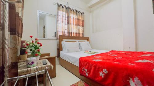 - une chambre avec un lit et une couverture rouge dans l'établissement Hotel New Royal Palace Dhanmondi, à Dhaka