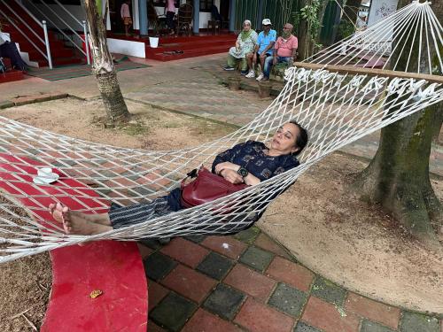 a woman laying in a hammock in a tree at Marari Beach Villas in Mararikulam