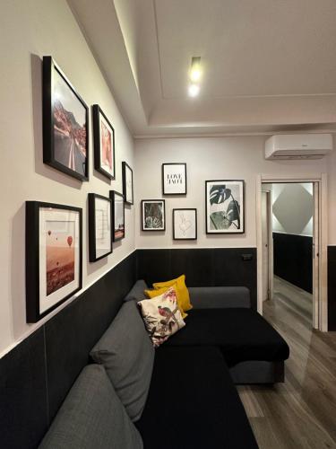 un soggiorno con divano e immagini appese al muro di Falco Luxury Home a Napoli