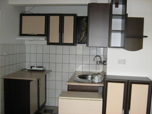 a small kitchen with brown cabinets and a sink at Guestrooms Ross in Veliko Tŭrnovo