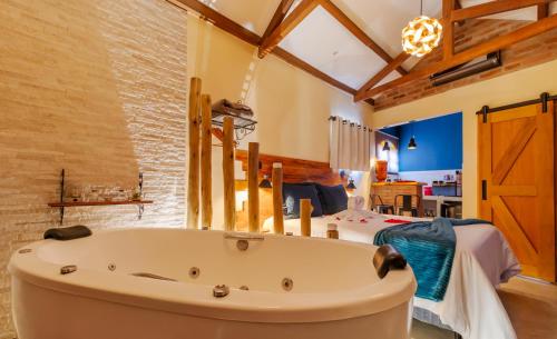 a large bathroom with a large tub in a room at Mantiqueira Flat in Santo Antônio do Pinhal