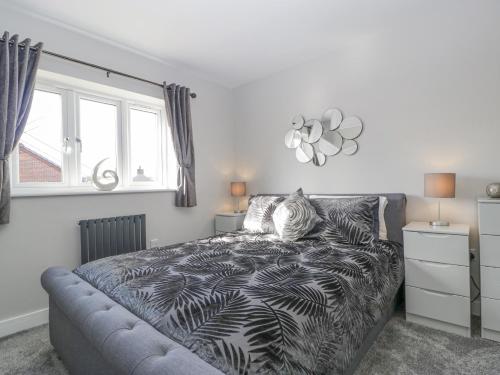 a bedroom with a bed with a black and white comforter at Aneths Annex in Drybrook