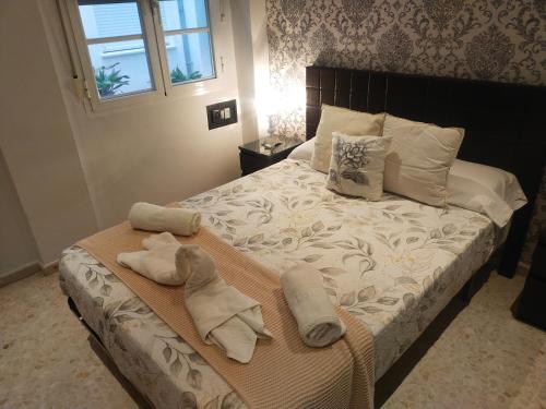 a bedroom with a bed with towels on it at CENTRO ANTEQUERA Apartamento Las Recoletas in Antequera