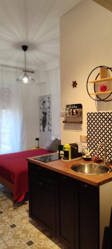 a kitchen with a sink and a bed in a room at Edahouse in Salerno