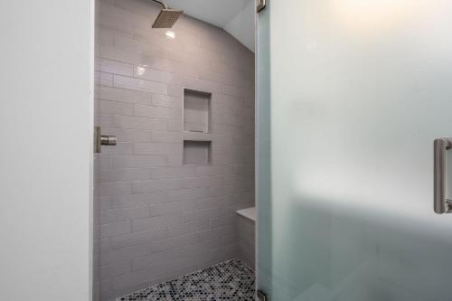 a bathroom with a shower with white tiles at 201 Main Street Chatham Cape Cod - - Sandpiper in Chatham