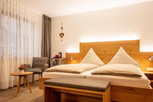 a hotel room with a bed and a chair at Zum Fässle in Hagnau