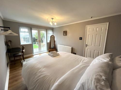 a bedroom with a large white bed and a window at Tranquil 3-bedroom bungalow 