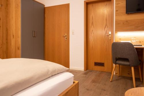 a bedroom with a bed and a desk and a chair at Zum Fässle in Hagnau