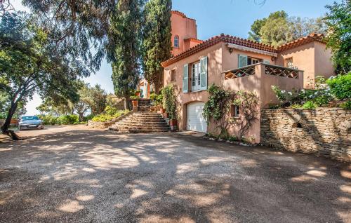 uma casa grande com uma parede de pedra e uma entrada em Villa la Malpagne, 400m2 les pieds dans l'eau em Rayol-Canadel-sur-Mer