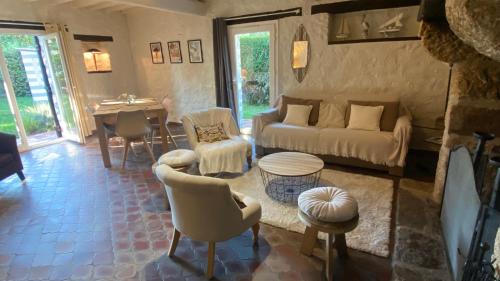 un salon avec un canapé, des chaises et une table dans l'établissement Villa a 2mn de la plage, à Saint-Georges-de-Didonne
